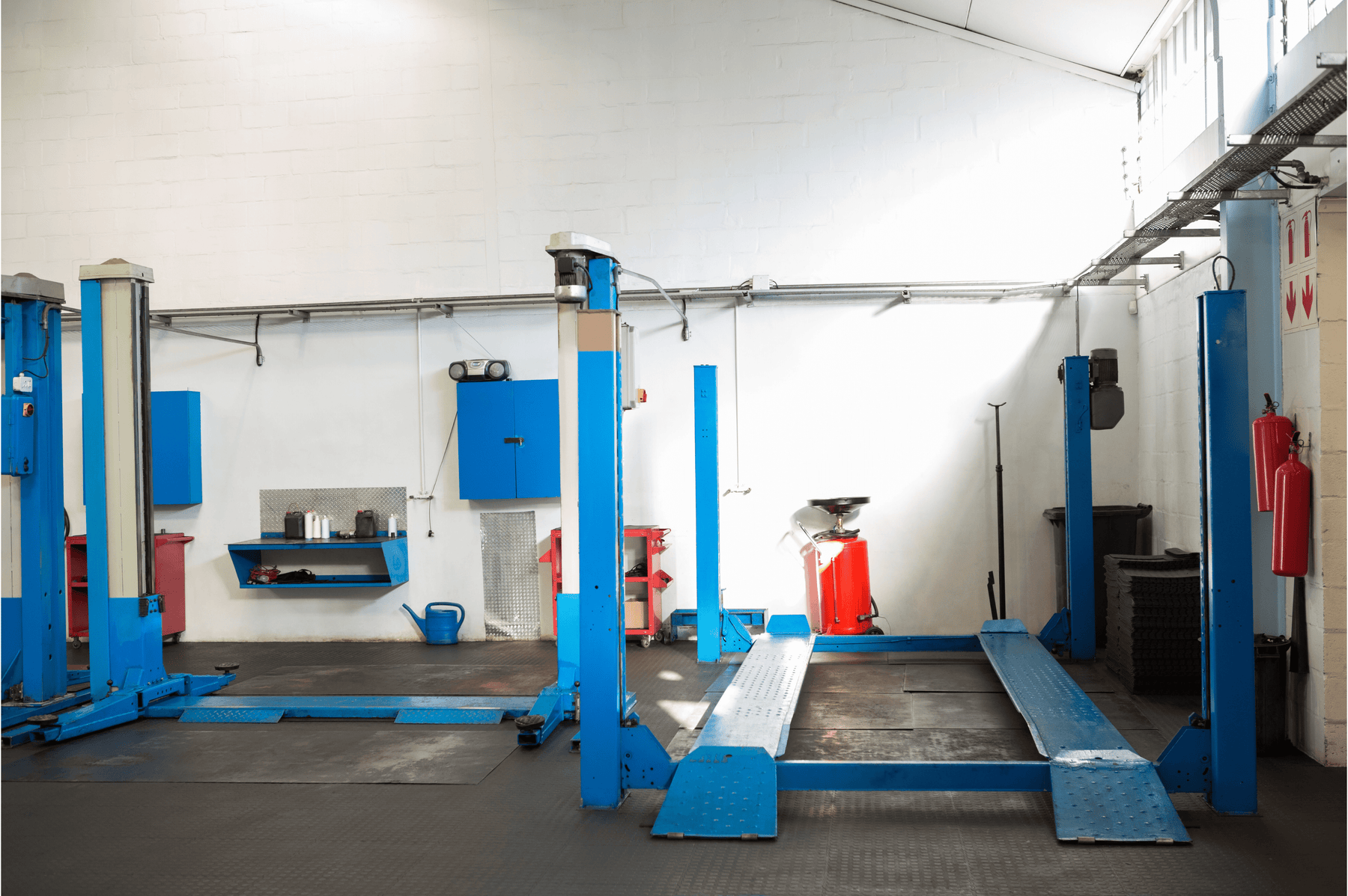 A 2 post and 4 post lift sitting side by side