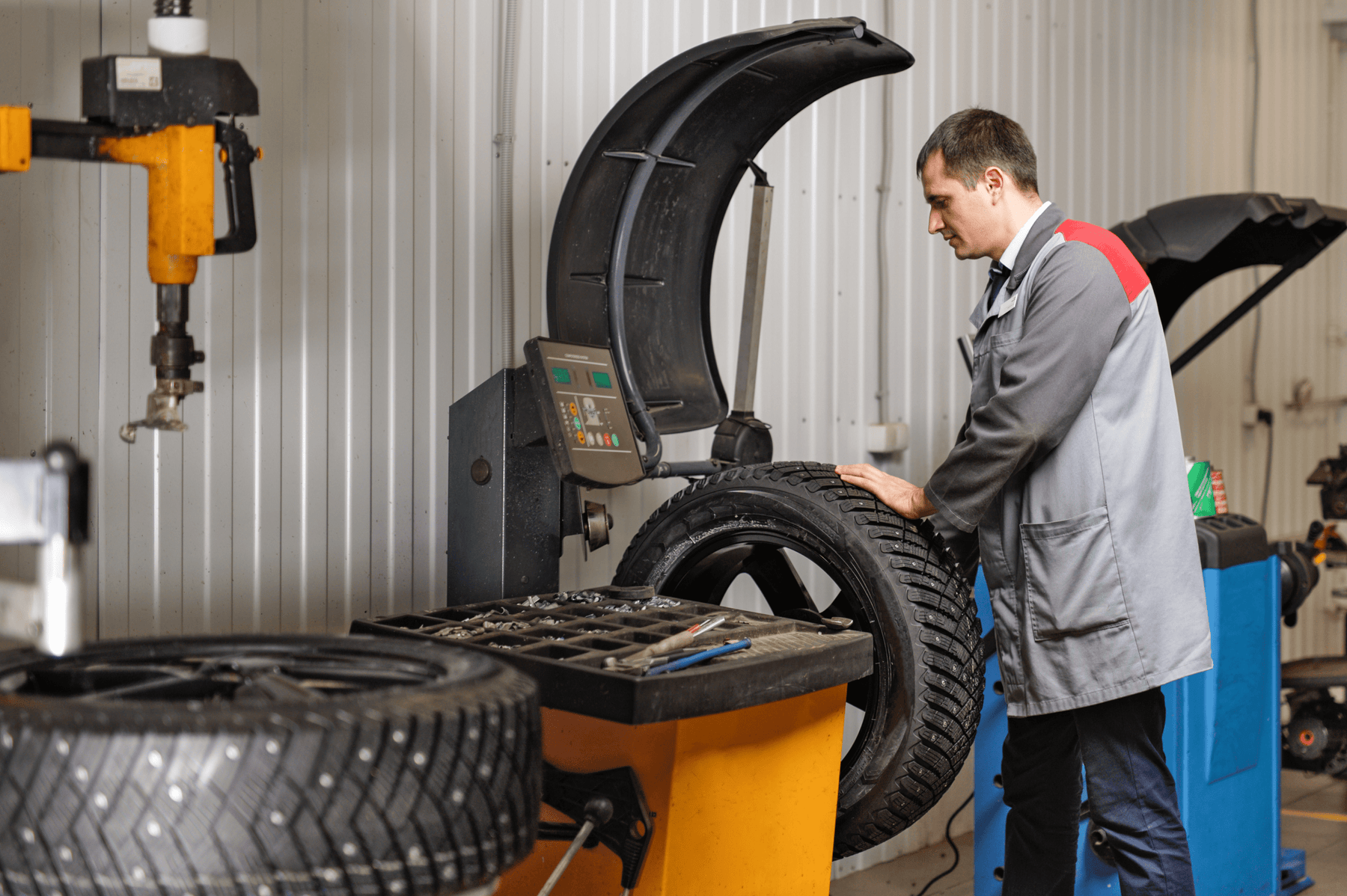 Mechanic using wheel balancer to install and balance studded tire