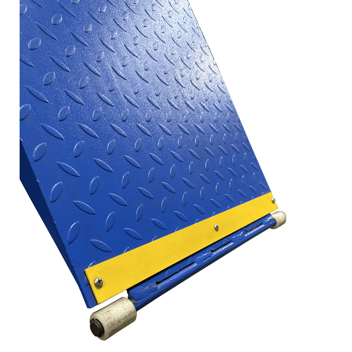 Close-up of a diamond plate steel ramp with yellow safety strip on a 4-post lift.