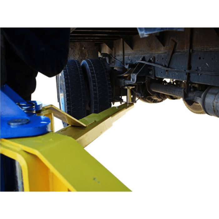 Close-up of the Atlas BP12000X lift arm engaged under a heavy-duty truck, illustrating robust contact with the frame and reinforced lifting geometry.