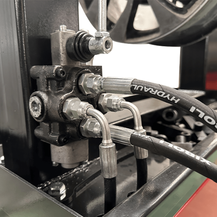 Close-up of the Katool WL69 Rim Straightening Machine’s hydraulic control block and hoses, ensuring precise pressure for accurate wheel repair.