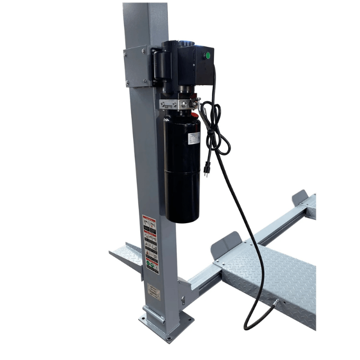 Close-up of the Triumph NSS-11 Vehicle Lift’s hydraulic power unit mounted on a steel column, with diamond-plate runways visible in the background.