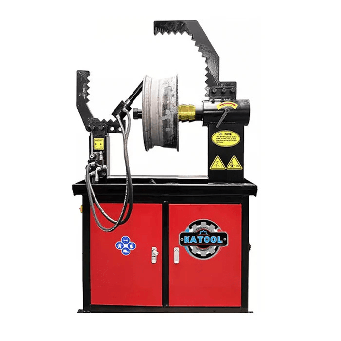 Front view of the Katool WL69 Rim Straightening Machine with large serrated clamp arms, a mounted damaged rim, and a red cabinet for wheel repair operations.