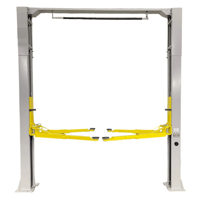 Front view of the Triumph NTO-9AE Lift showcasing its overhead cable system, dual post structure, and extended yellow lift arms for optimal vehicle support.