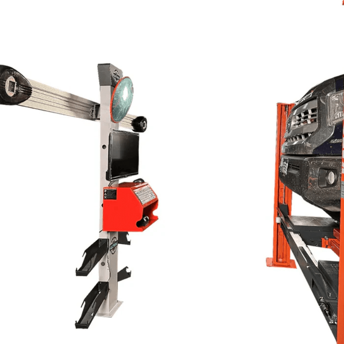 Side perspective of the Katool KT-AV533 alignment machine and a truck on a lift, highlighting the crossbeam design, monitor, and reflective targets for precise wheel calibration.