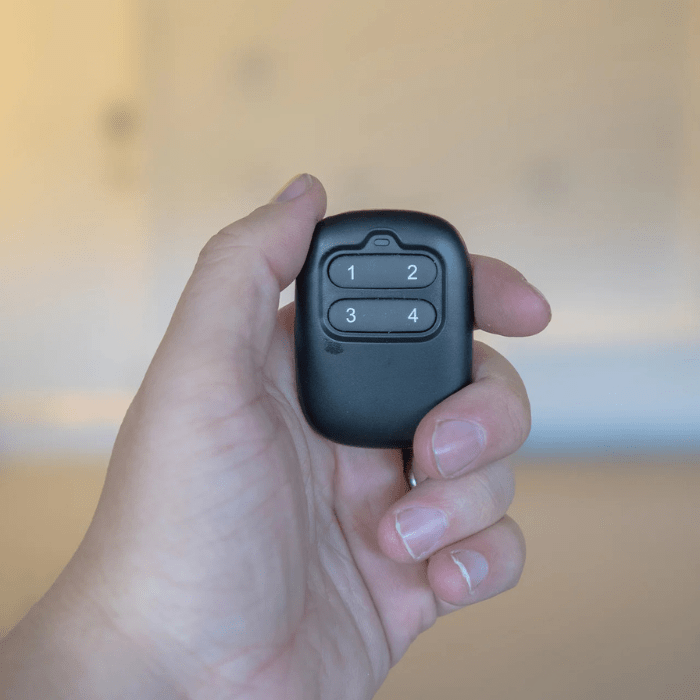 Someone holding the Auxx Extra Wireless Remote in their hand