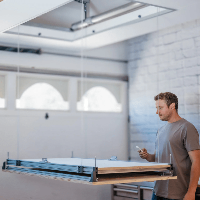 Someone using the remote to move the Automatic Attic Storage Lift