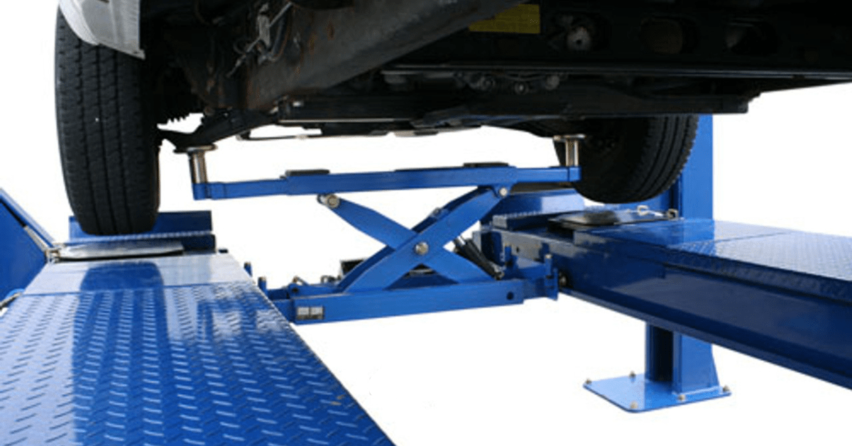 Automotive rolling bridge jack attached to a 4-post lift platform for wheels-off service and undercar access.