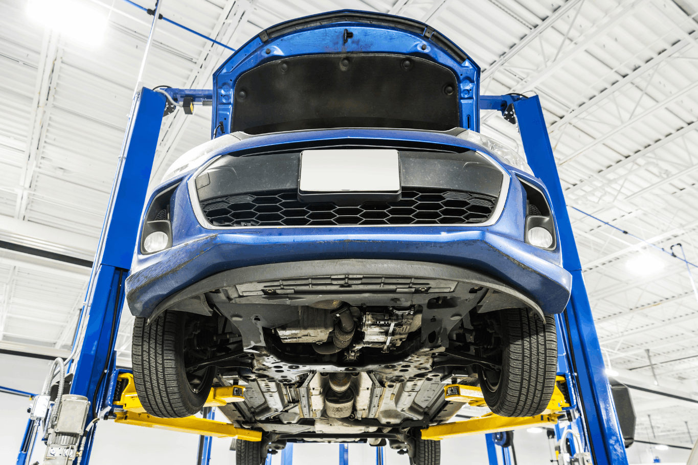 Front side upward view of a vehicle on a 2 post lift