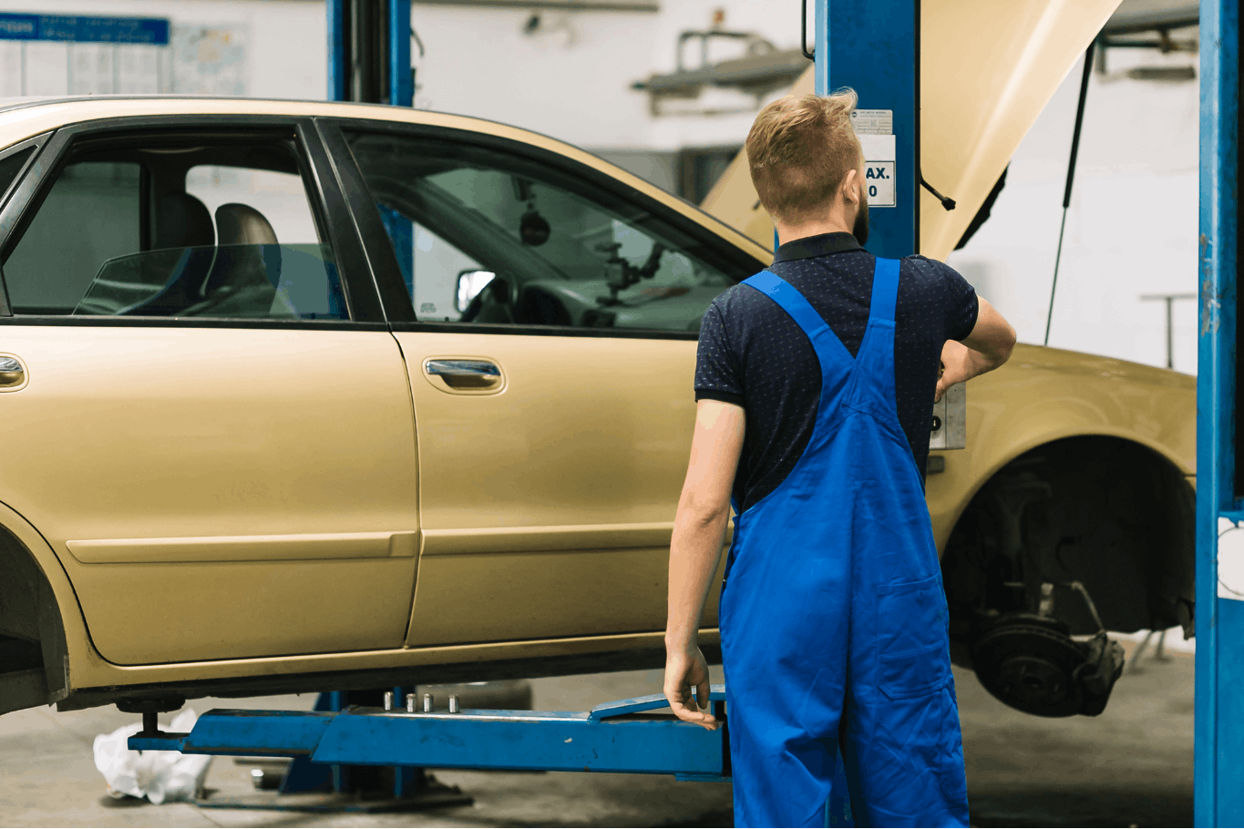 Machanic Standing next to car lift lowered
