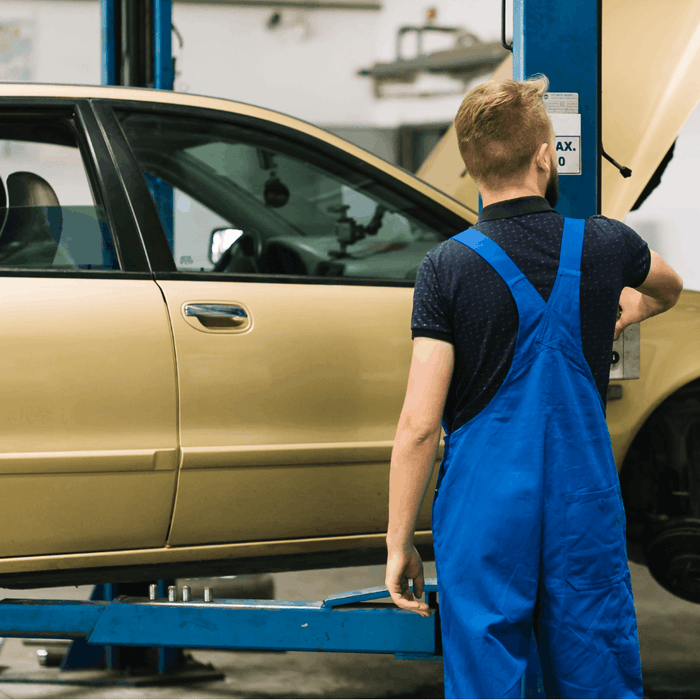 Machanic Standing next to car lift lowered