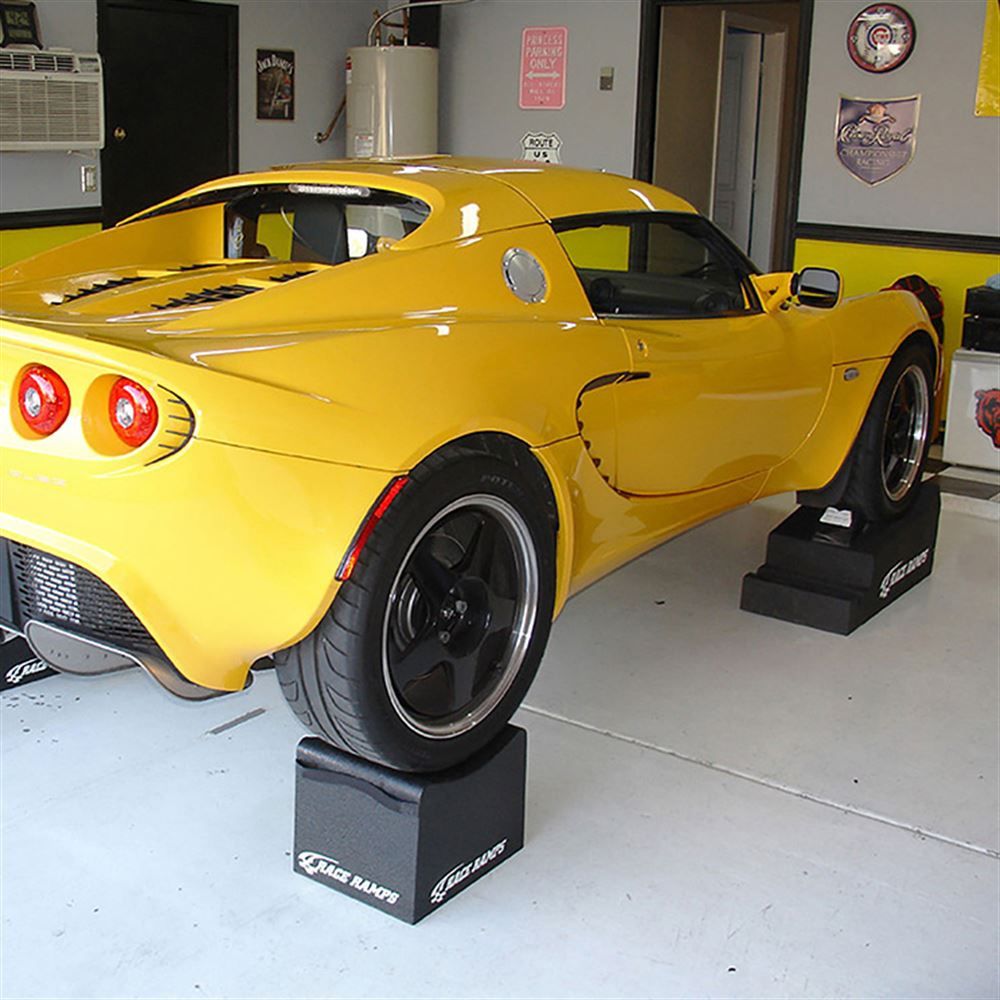 Lotus Elise raised on Race Ramps 12 inch wheel cribs in a garage