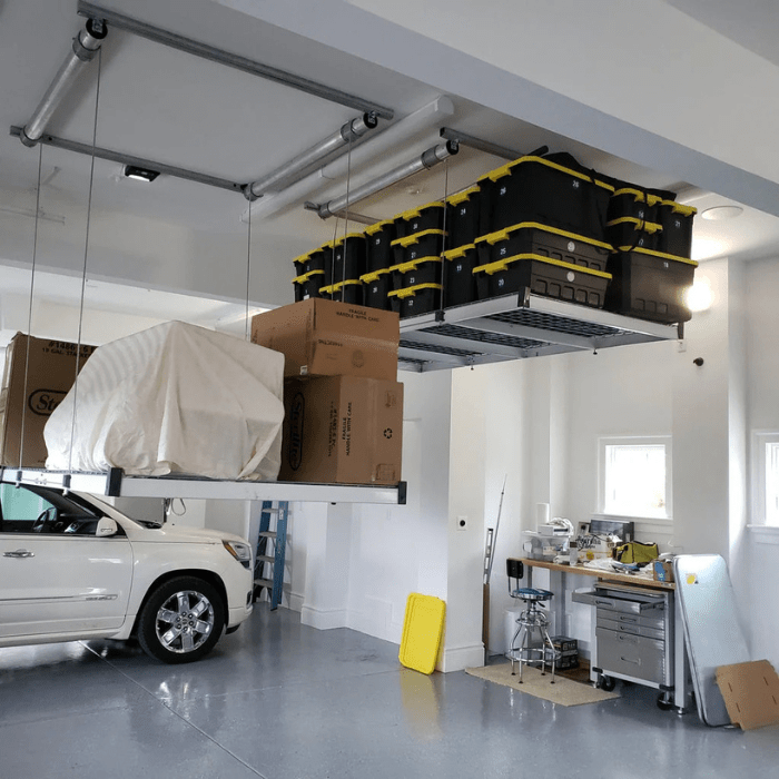 2  AuxxLifts in a garage one loaded with boxes one loaded with totes lowered right side view