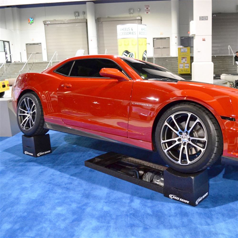 Camaro raised on Race Ramps wheel cribs in a showroom