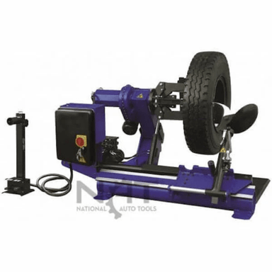 Angled view of the Triumph NTC-690 Wheel Changer handling a heavy-duty tire with its strong clamp arms and motorized rotating mechanism for truck or bus wheel servicing.