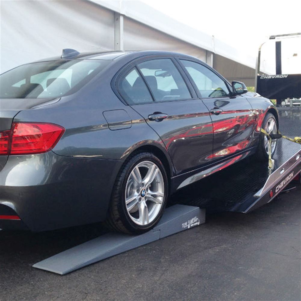 BMW sedan driving up Race Ramps tow ramps onto a flatbed tow truck
