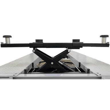 Close-up of the Triumph RJ-5000 Bridge Jack mounted on a four-post lift, featuring adjustable lift pads and a sturdy scissor mechanism for reliable vehicle support.