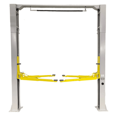 Front view of the Triumph NTO-9AE Lift showcasing its overhead cable system, dual post structure, and extended yellow lift arms for optimal vehicle support.