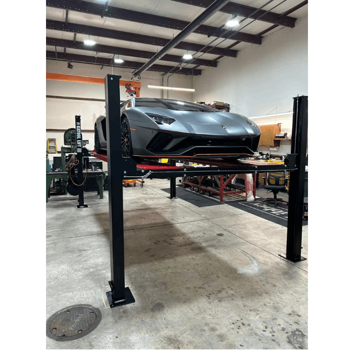 Gray performance car elevated on 4H950 four post vehicle lift in a professional garage bay