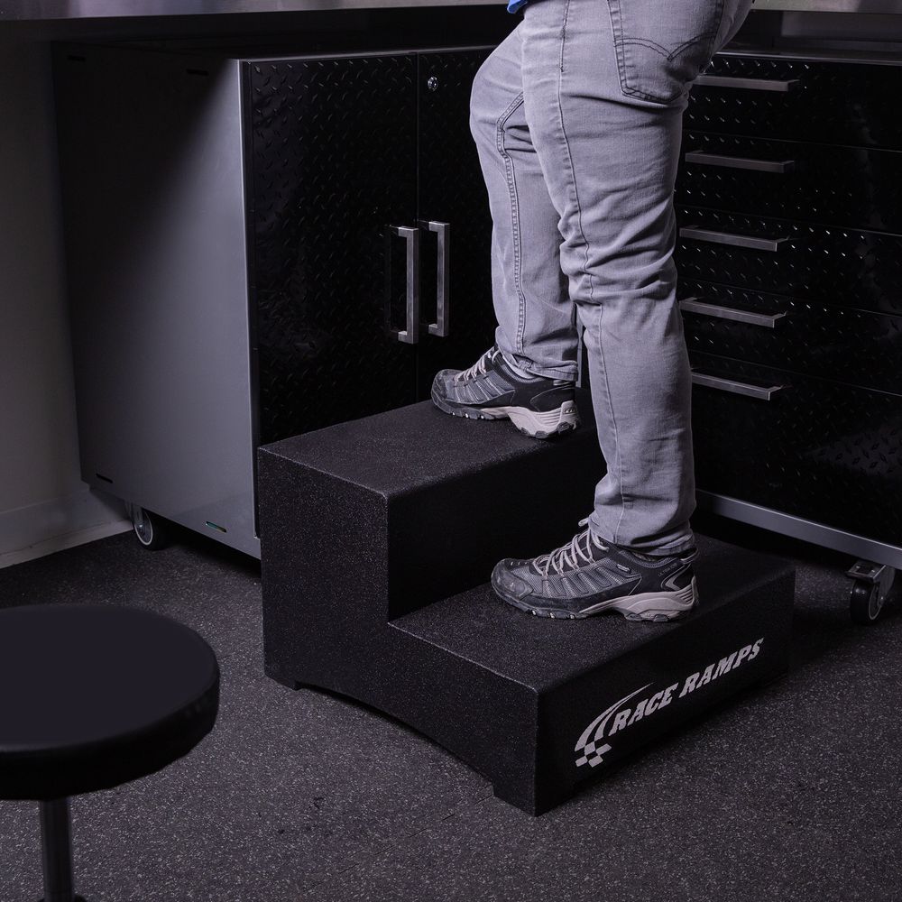 Technician standing on a Race Ramps two step to reach a tool cabinet