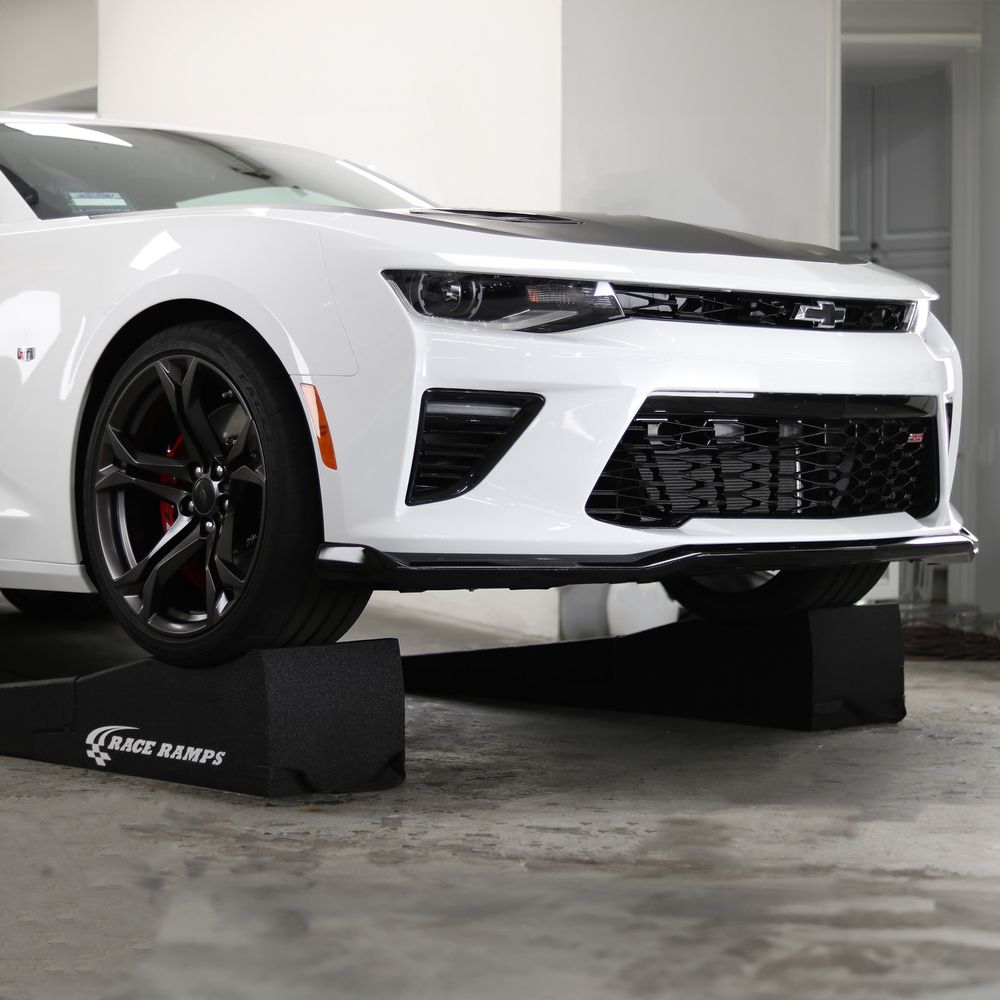 Camaro raised on Race Ramps 80 inch combo ramps in a garage