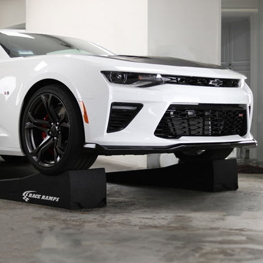Camaro raised on Race Ramps 80 inch combo ramps in a garage