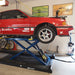 Low car raised on a scissor lift after driving up Race Ramps car lift ramps