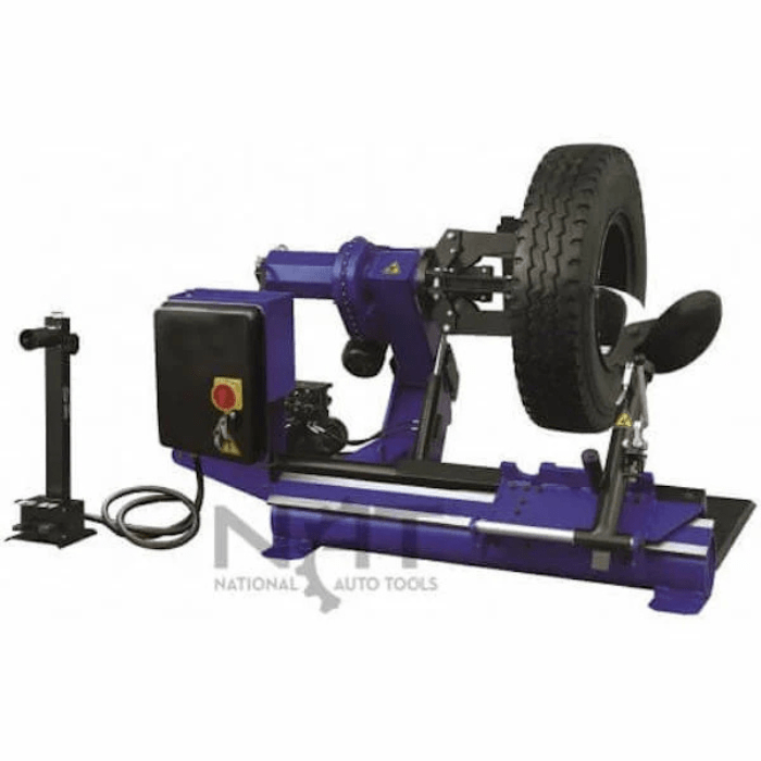 Side view of the Triumph NTC-650 Wheel Changer handling a heavy truck tire, featuring robust clamp arms and a powerful rotating assembly for large-scale tire service.
