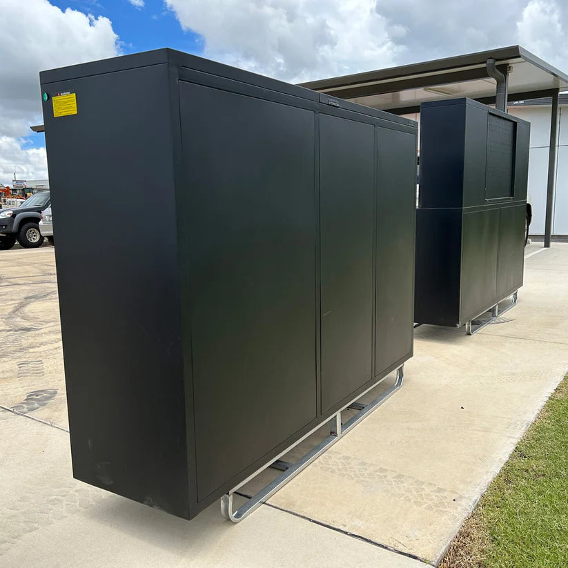 Two black Chery Industrial garage cabinets lined up outside on galvanized skid bases