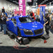 Vinyl wrap being installed on a car raised on Race Ramps Restyler Ramps