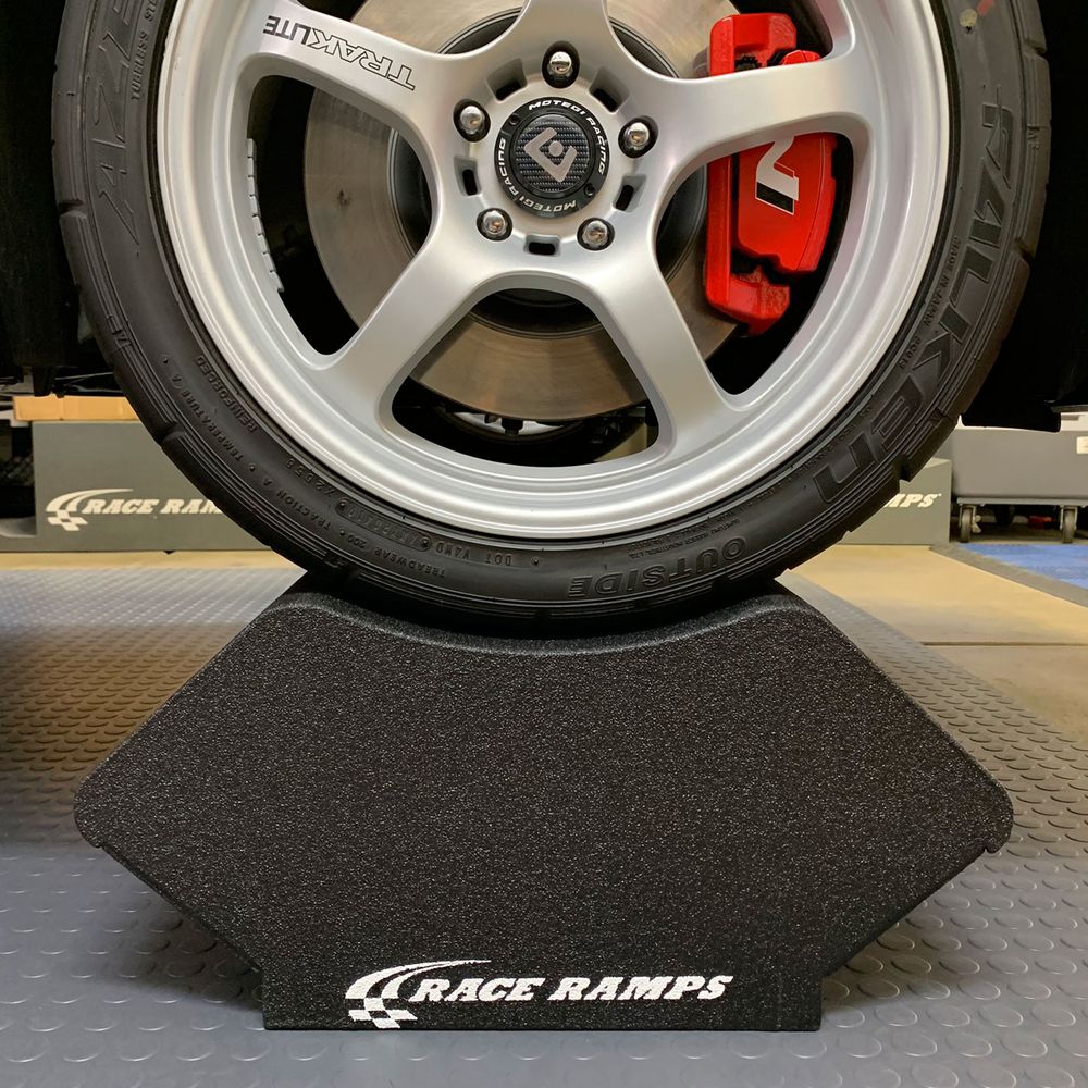 Wheel and tire resting in a Race Ramps Crib Cruiser cradle