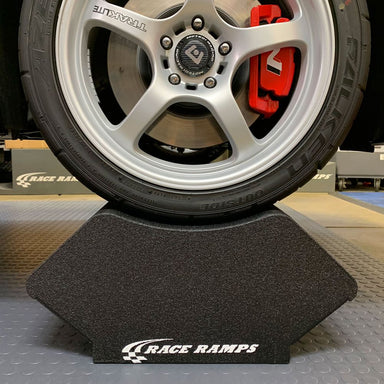 Wheel and tire resting in a Race Ramps Crib Cruiser cradle