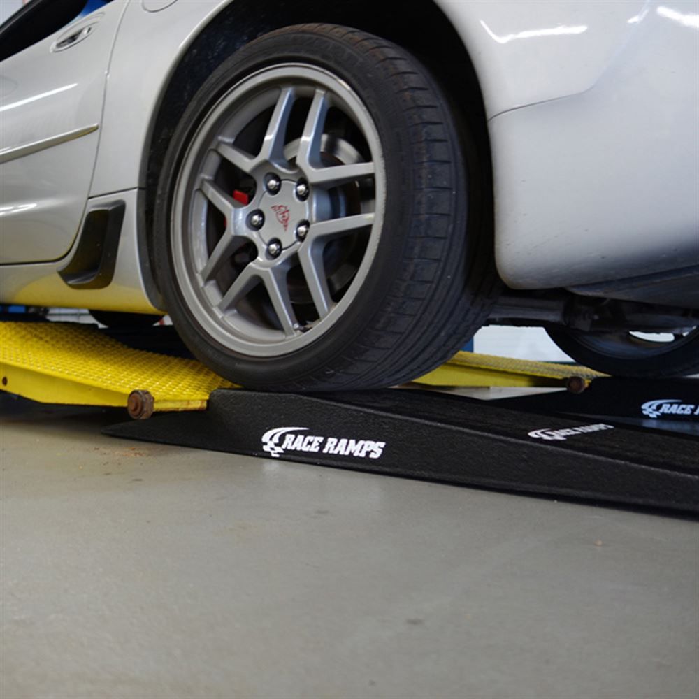 Race Ramps shop ramp positioned alongside a two post lift arm
