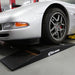 Front wheel of a low car climbing a Race Ramps shop ramp