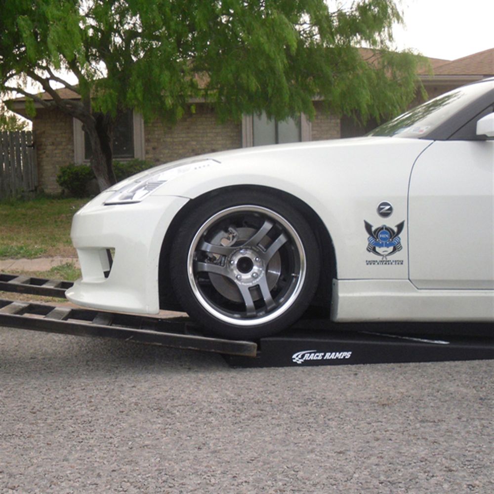White Nissan 350Z with low front bumper rolling onto a Race Ramps RR-TR-5 trailer ramp