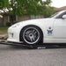 White sports car with a front splitter climbing a Race Ramps RR-TR-6 trailer ramp