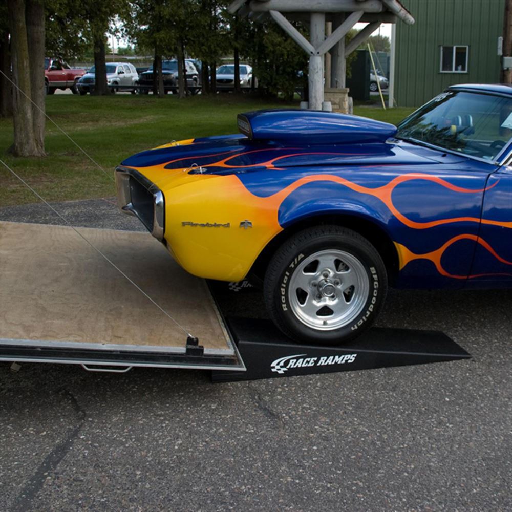 Flamed Firebird driving up a Race Ramps RR-TR-8XL trailer ramp