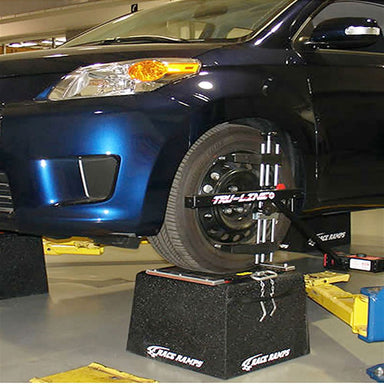 Car raised on Race Ramps wheel stands during an alignment in a shop